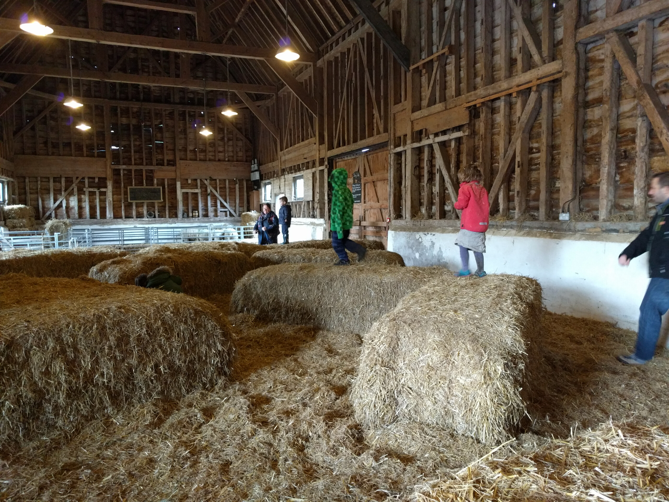 My kids playing on straw bales in a barn at Wimpole 9 years ago